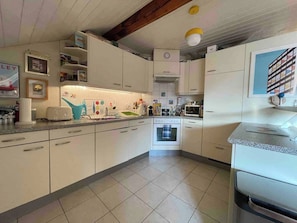 A kitchen with white cabinets, a microwave, a toaster, and a sink. - Stylish Loft - Amazing Views (Geneva)