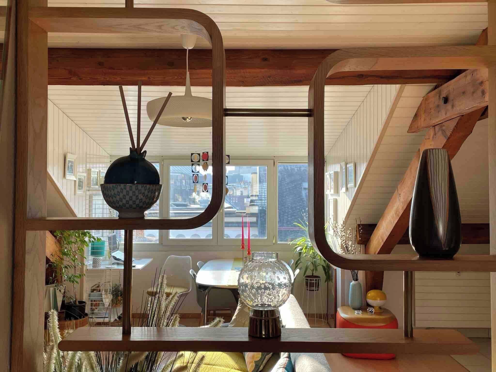 Ein Zimmer mit Holzbalkendecke, einem Tisch mit Stühlen, einer Vase und einem Globus.
