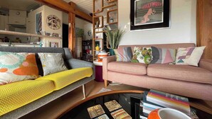 A cozy living room with a sofa, a coffee table with magazines, and a bookshelf. - Stylish Loft - Amazing Views (Geneva)