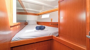 A compact cabin with a bed, a small window, and a wooden door. - Sun-Kissed Sailing Adventure in Islas Sarónicas (Alimos)