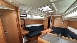 Ein kompaktes Wohnmobil-Interieur mit Küchenzeile, Sitzecke und Dachfenstern.