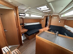Ein kompaktes Wohnmobil-Interieur mit Küchenzeile, Sitzecke und Dachfenstern.