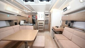 Ein kompaktes Wohnmobil-Interieur mit Essbereich, Sitzgelegenheiten und einer Küchenzeile.