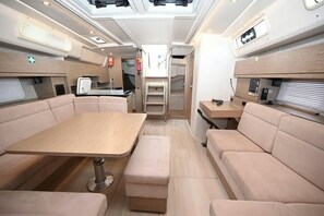 A compact RV interior with a dining area, seating, and a kitchenette. - Sun-Kissed Sailing Adventure in the Ionian Islands, Lefkada (Lefkada)