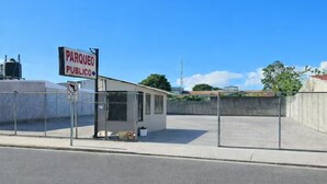 Un estacionamiento público cercado con un letrero que indica que es para uso público.