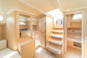 Ein kompaktes Wohnmobil-Interieur mit einer Küchenzeile, einer kleinen Sitzecke und einer Schlafkabine.