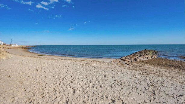 A beach with clear skies, a sandy shore, and a rocky outcrop. - 450 ft to Raycroft Beach, Game Room, Dog Friendly! (Dennis)