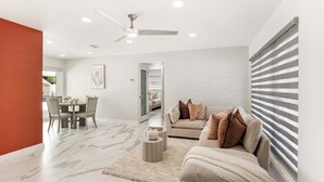 A modern living room with a sofa, coffee table, and dining area. - Modern home with Jacuzzi/ Near Siesta Key Beach (Sarasota)