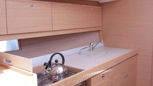 Une petite cuisine équipée d’une cuisinière, d’une bouilloire et d’un évier.