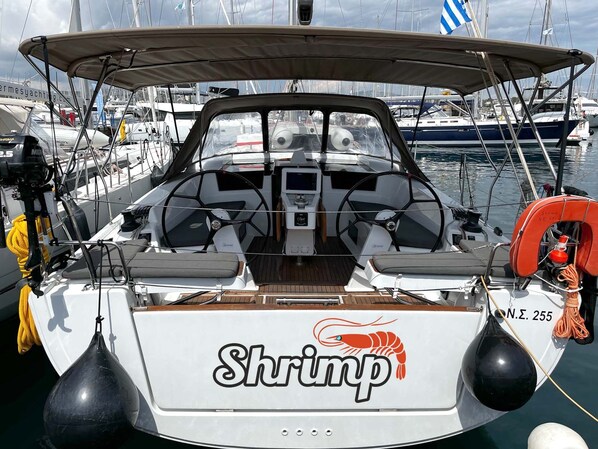 Een boot met een 'Shrimp' logo, een stuurwiel en een reddingsboei.