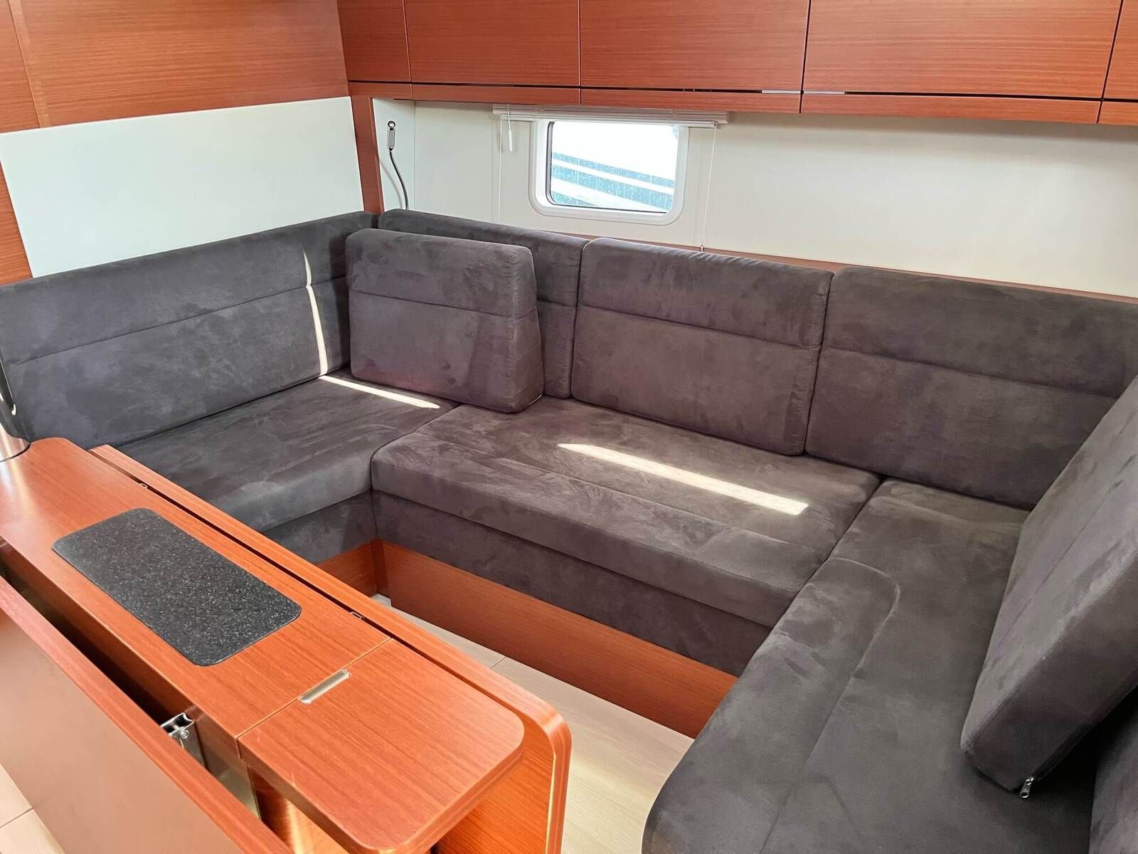 A compact living area with a sofa, a small table, and wooden cabinets.