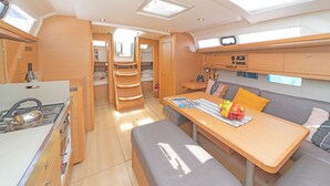 Un intérieur compact et bien éclairé, comprenant un coin cuisine, un espace repas et un coin salon.