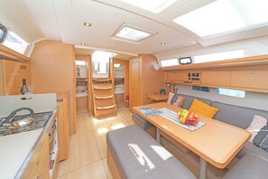 A compact, well-lit interior with a kitchenette, dining area, and seating space. - Sun-Kissed Sailing Adventure in the Ionian Islands, Lefkada (Lefkada)