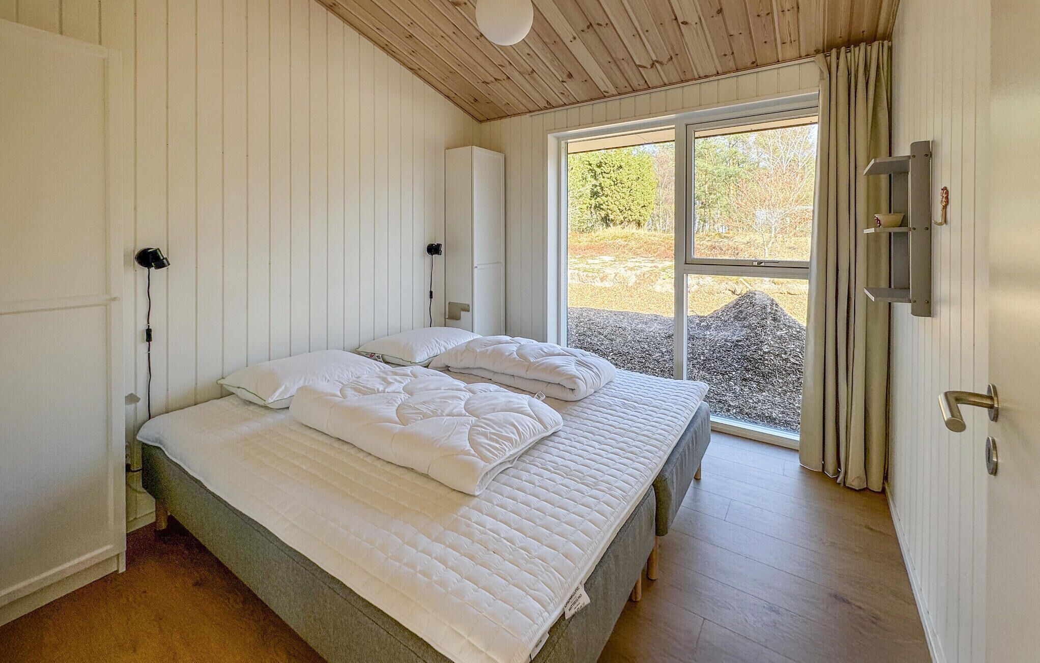 Ein Schlafzimmer mit Bett, Fenster und Tür.