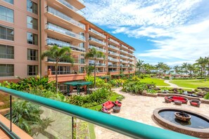 Um hotel com vários andares, área de estar externa e um jardim bem cuidado.