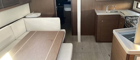 A compact kitchenette with a stove, sink, and storage cabinets.