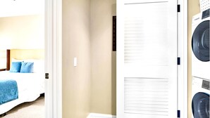 A hotel room with a bed, a washing machine, and a dryer. - Honua Kai 3 Free Cars KBM Resorts Front Alii Suite 3 Units, 6 Bedrooms HK Ml-3203 (Kaanapali)