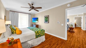 A hotel room with a bed, a ceiling fan, a TV, a painting, and a wooden floor. - Honua Kai 3 Free Cars KBM Resorts Front Alii Suite 3 Units, 6 Bedrooms HK Ml-3161 (Kaanapali)