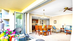 A dining area with a glass table, chairs, and a view of the kitchen. - Honua Kai 4 Free Cars KBM Resorts Front Alii Suite 4 Units, 8 Bedrooms HK Ml-3164 (Kaanapali)