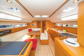 Een jachtinterieur met een eethoek, zitplaatsen, een keuken en kombuis.