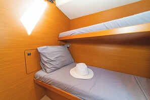 Ein Stockbett mit Kissen und Hut auf der unteren Koje.