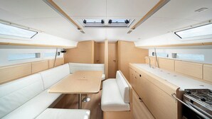Een compact, modern interieur met een centrale tafel, comfortabele zithoek en een kitchenette.