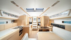 Een ruimtelijk ingerichte ruimte met kitchenette, zithoek en dakramen.