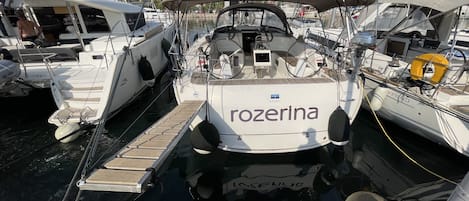 Un port de plaisance où sont amarrés plusieurs bateaux, dont un qui s’appelle « Rozerina ».