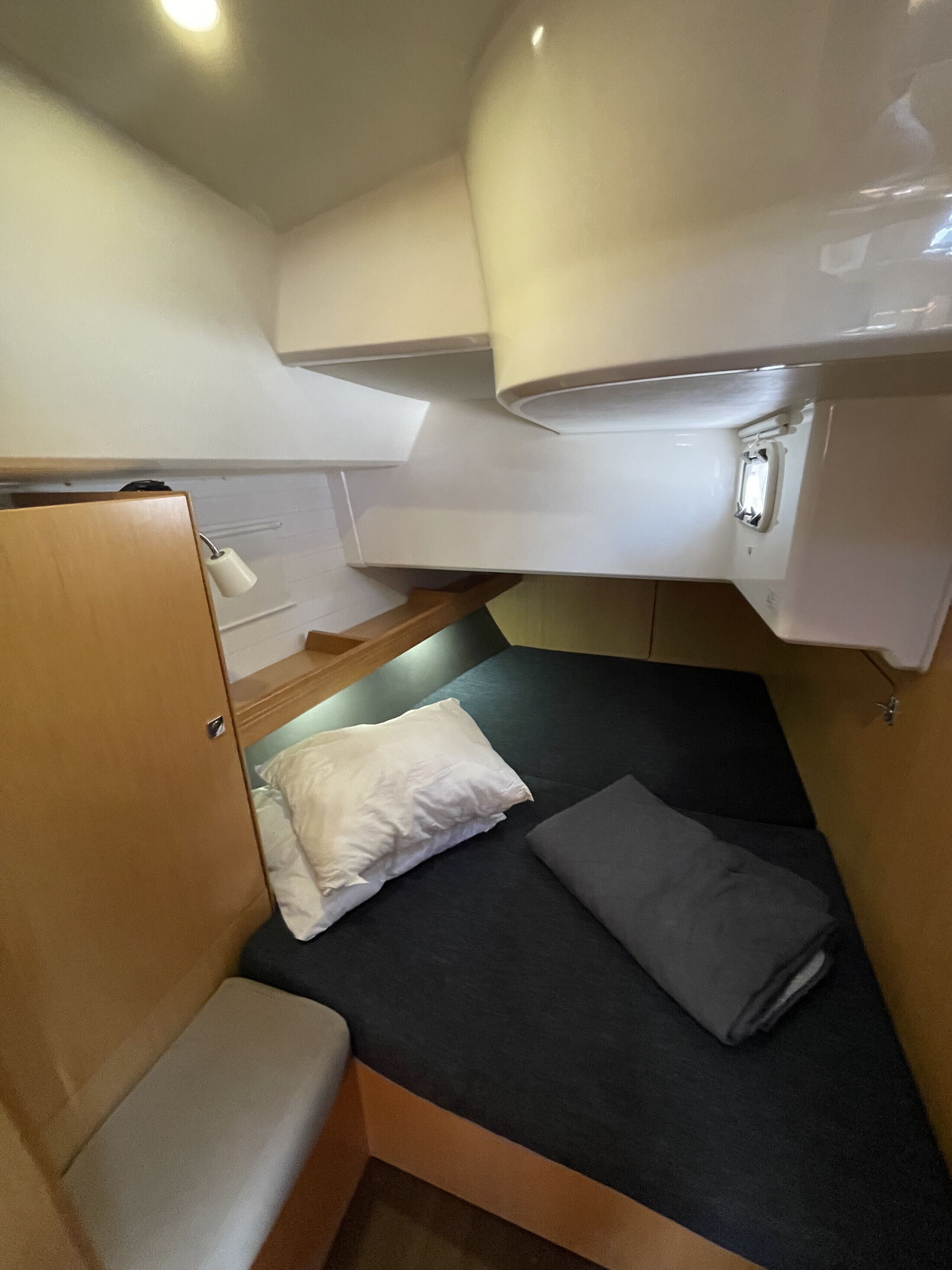 Ein kleines Zimmer mit Etagenbett, Tisch und Deckenleuchte.