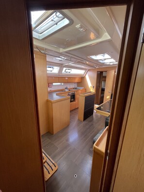 A compact galley with a sink, stove, and storage cabinets. - Sun-Kissed Sailing Adventure in Islas Sarónicas (Alimos)