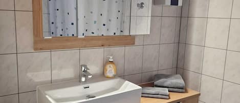 Chuveiro, secador de cabelo, toalhas de banho, sabonete