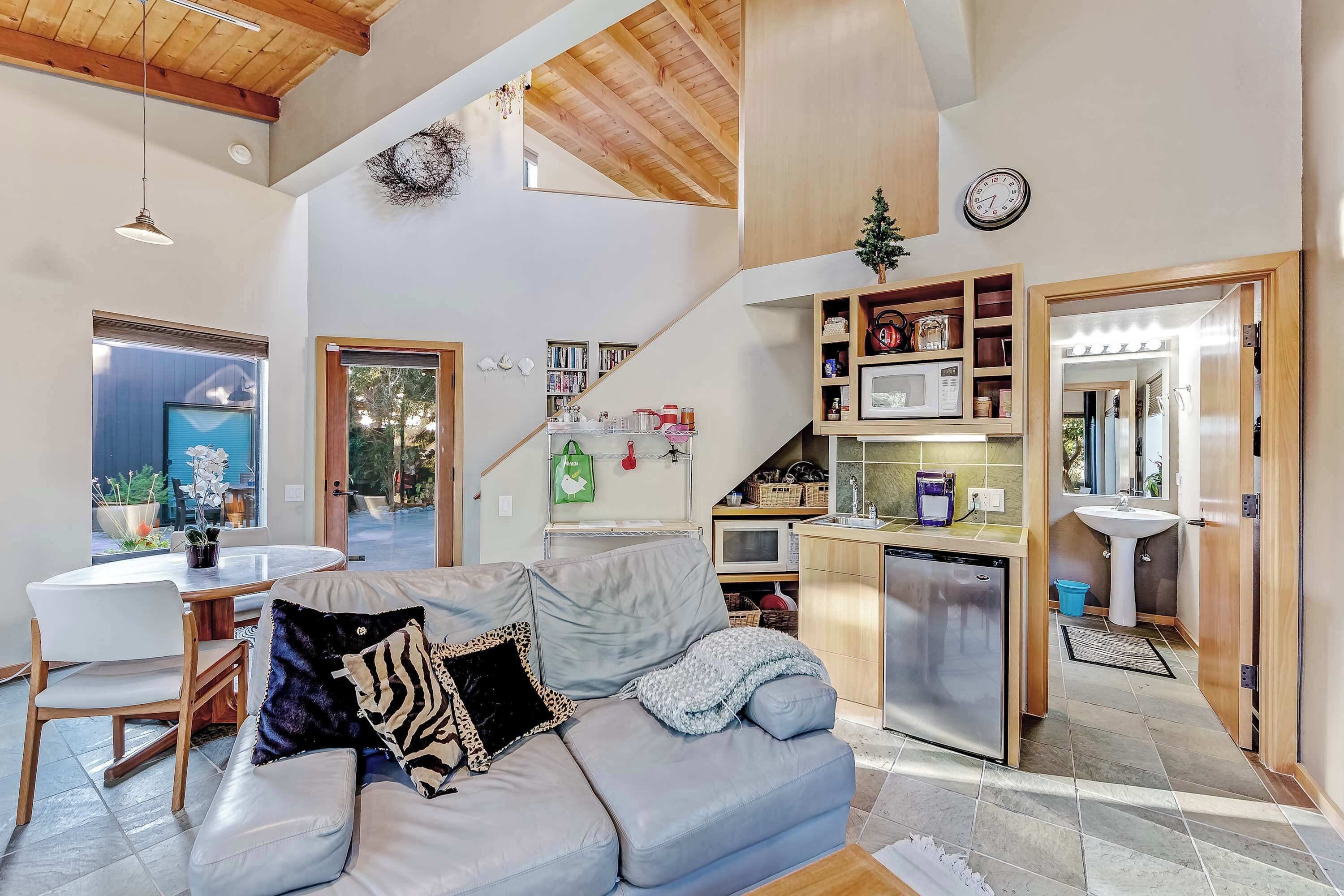A modern living area with a sofa, dining table, and kitchen.