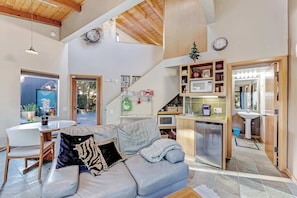 A modern living area with a sofa, dining table, and kitchen. - Sea Ranch 1BR meadow cottage with hot tub near Del Mar pool (Sea Ranch)