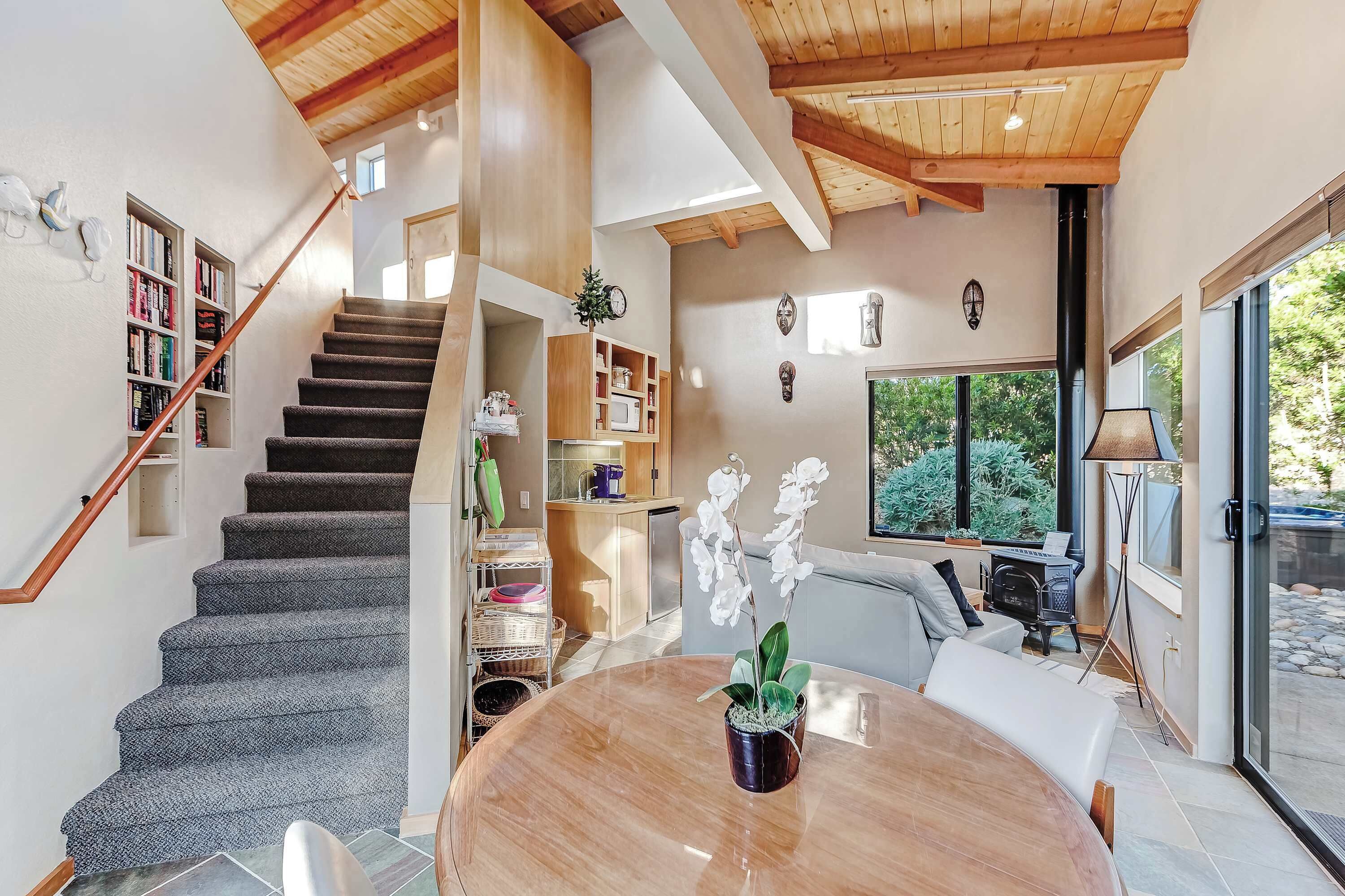 Un interior moderno con una escalera, una zona de comedor y una cocina.