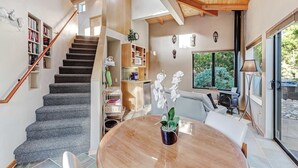 Un intérieur moderne comprenant un escalier, un coin repas et une cuisine.