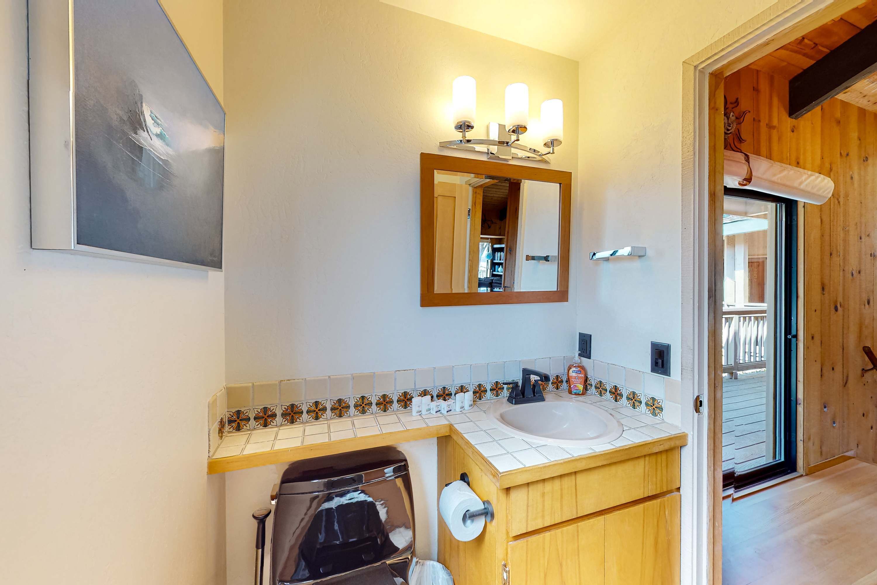 Een badkamer met een wastafel, spiegel en handdoekhouder.