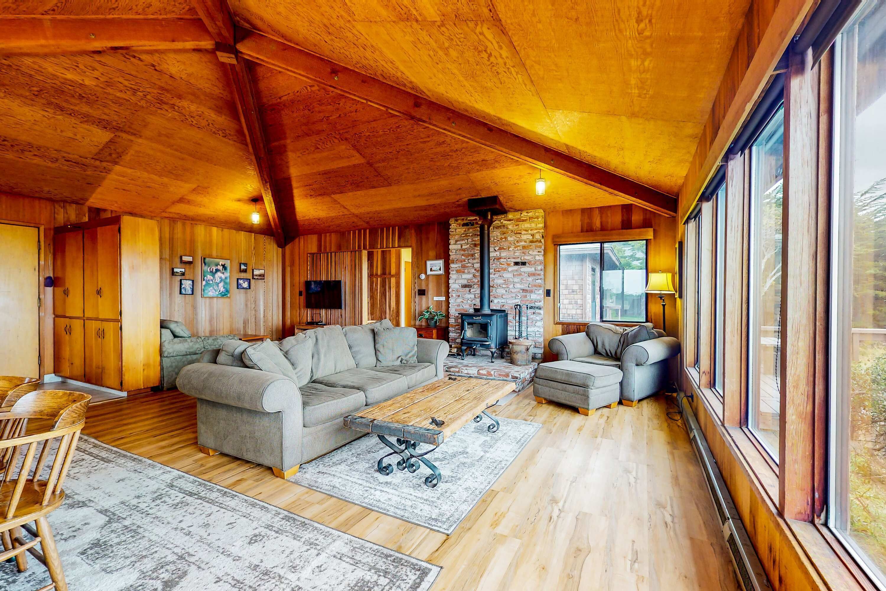 A cozy living room with a large sectional sofa, a fireplace, and a dining area with wooden furniture.