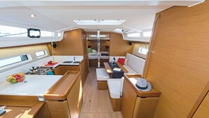 Un intérieur compact et bien éclairé, avec un espace salon central, une petite kitchenette et une fenêtre laissant entrer la lumière naturelle.