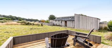 A wooden deck with a chair and a wheelbarrow.