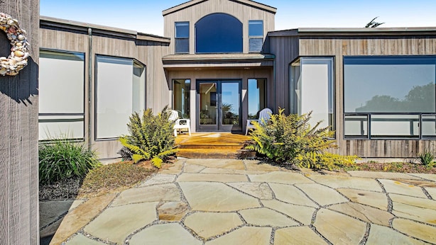 A modern house with a stone pathway leading to a wooden deck. - Sea Ranch 2BR modern ocean-view home on golf course with hot tub (Sea Ranch)