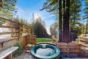 A wooden deck with a hot tub, wooden benches, and a wooden fence. - Sea Ranch 2BR Binker Barn with hot tub, yard & fire pit — dogs welcome (Sea Ranch)