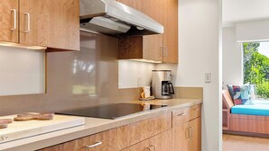 Eine moderne Küche mit Edelstahlgeräten, Holzschränken und einem eingebauten Backofen.