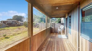Um deck de madeira com vista para um quintal e uma casa.