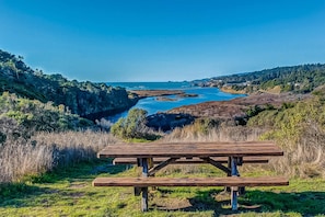 Ein Picknicktisch in einer natürlichen Umgebung mit Blick auf einen Fluss und Hügel.