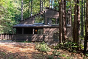 A cabin with a sloped roof, large windows, and a wooden deck. - Sea Ranch 2BR award-winning redwood forest retreat on private acre (Sea Ranch)