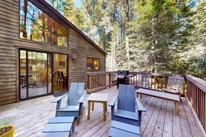 A wooden deck with outdoor seating, a grill, and a glass door leading to an interior space. - Sea Ranch 2BR award-winning redwood forest retreat on private acre (Sea Ranch)
