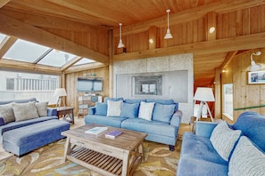 Ein gemütliches Zimmer mit einem blauen Sofagarnitur, einem Holztisch und einem Kamin aus Stein.