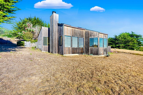 Experience the charm of Clemons' Cottage from the outside, featuring a unique design that blends seamlessly with the beautiful coastal landscape.