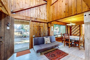 A wooden interior with a sofa, dining table, and chairs. - Sea Ranch Binker Barn with hot tub, spa shower & ocean views (Sea Ranch)