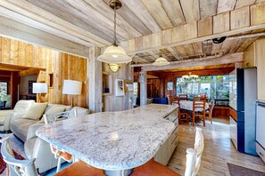 A kitchen with a marble countertop, wooden ceiling, and pendant lighting. - Sea Ranch Binker Barn with hot tub, spa shower & ocean views (Sea Ranch)